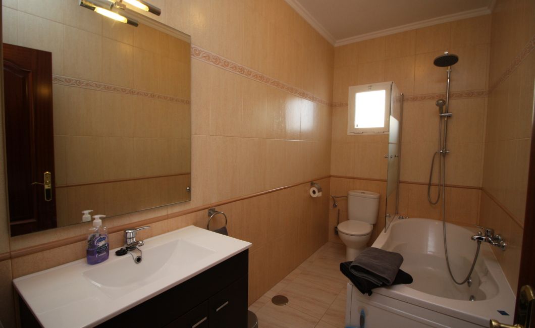 Spacious bathroom with spa bath.